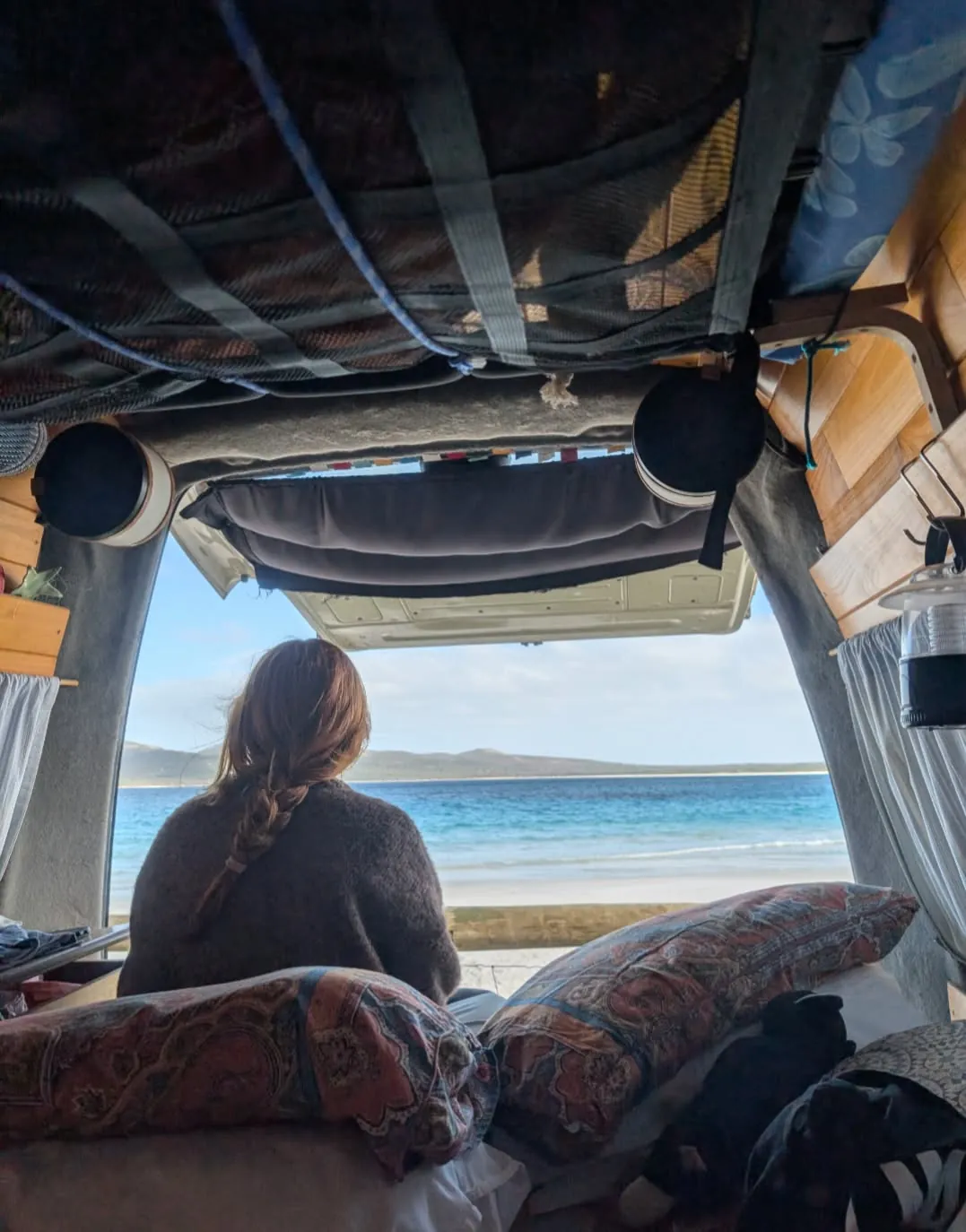 View from the bed out the open tailgate, a person looking at the beach